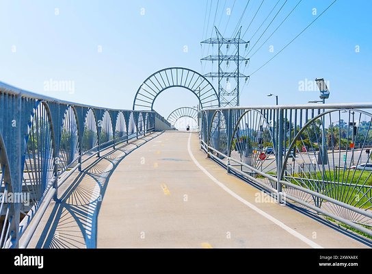 los-angeles-california-april-21-2024-wide-pedestrian-bridge-over-los-angeles-river-with-power-lines-and-clear-sky-in-background-2XWXA8X